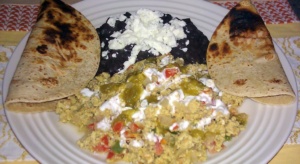 Mexican Breakfast Scrambled eggs with salsa accompanied with refried beans and tortillas