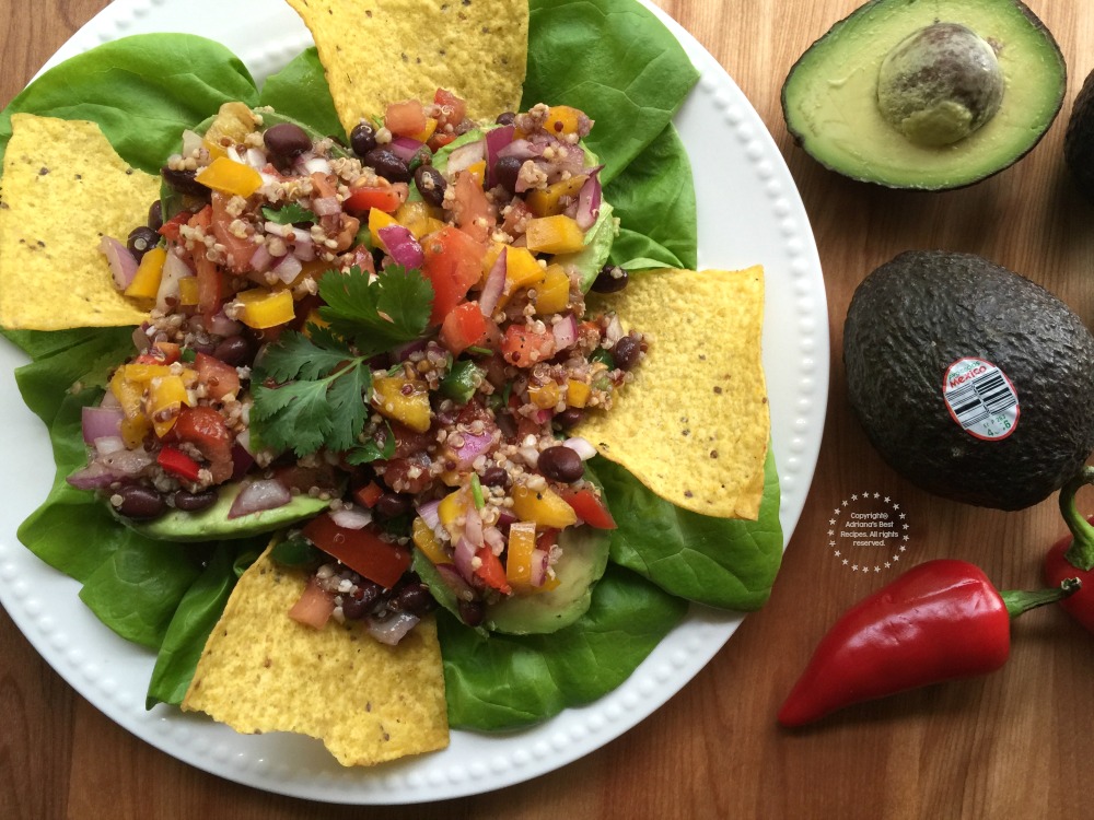 Garnishing the Quinoa Stuffed Avocados with few corn chips to add crunch