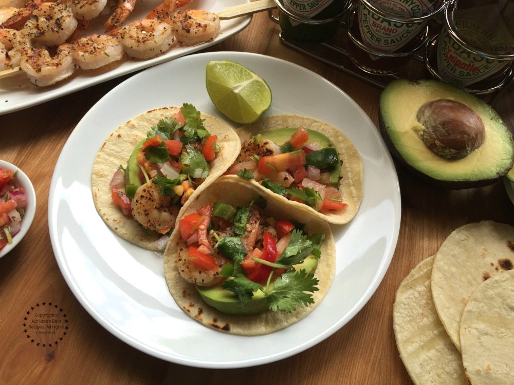 Grilled Shrimp Tacos garnished with avocado, pico de gallo and lime juice