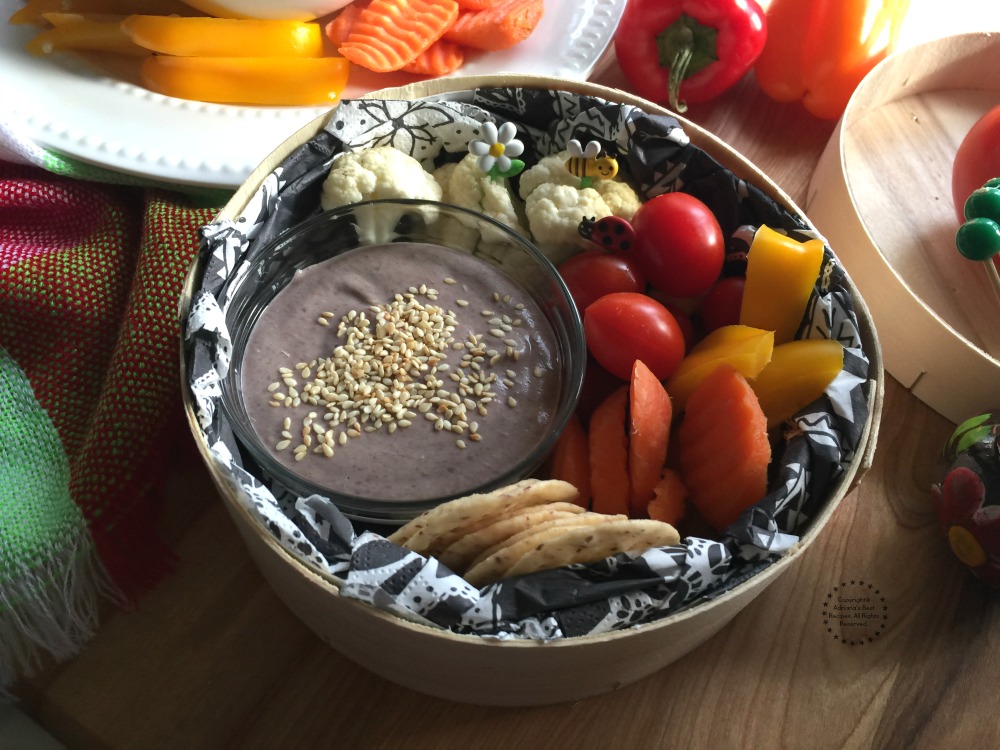 Coloca un poco del humus de frijol en un recipiente y acompaña de verduras y galletas