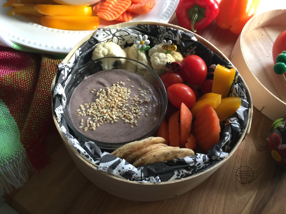 Put some black bean hummus in a container and add the veggies and the crackers Put some black bean hummus in a container and add the veggies and the crackers