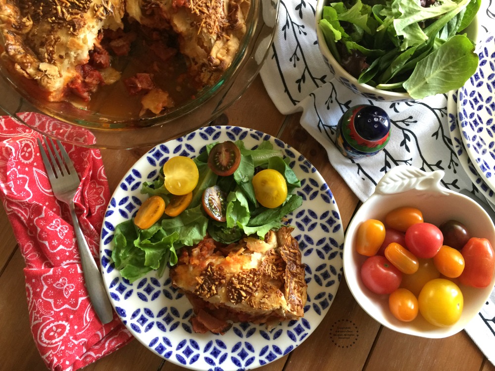 a slice of warm pie with salad served on a plate