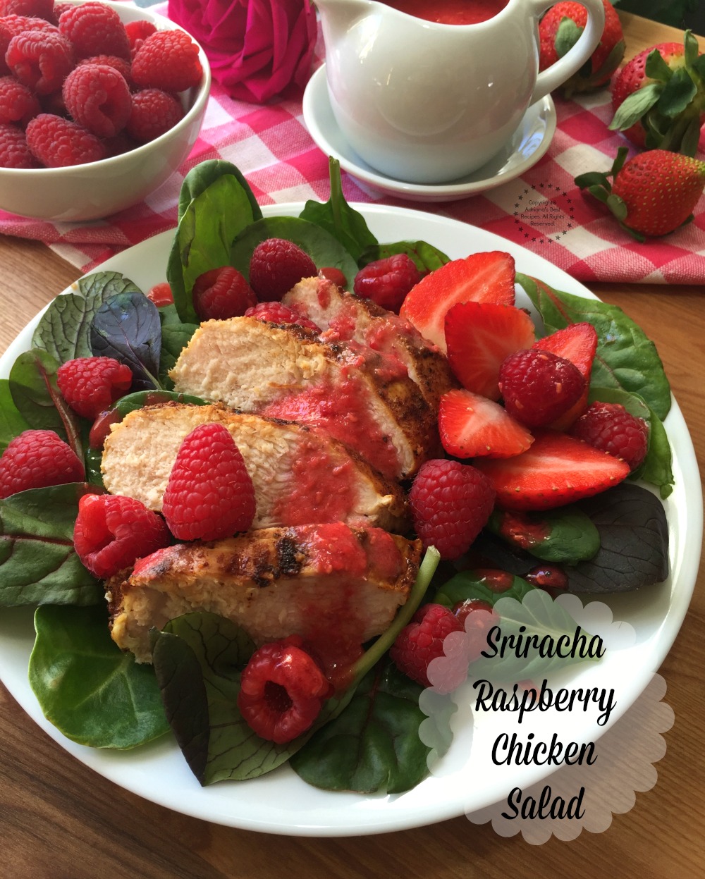 Lovely Sriracha Raspberry Chicken Salad, made with fresh greens, raspberries, grilled chicken and a homemade spicy raspberry dressing