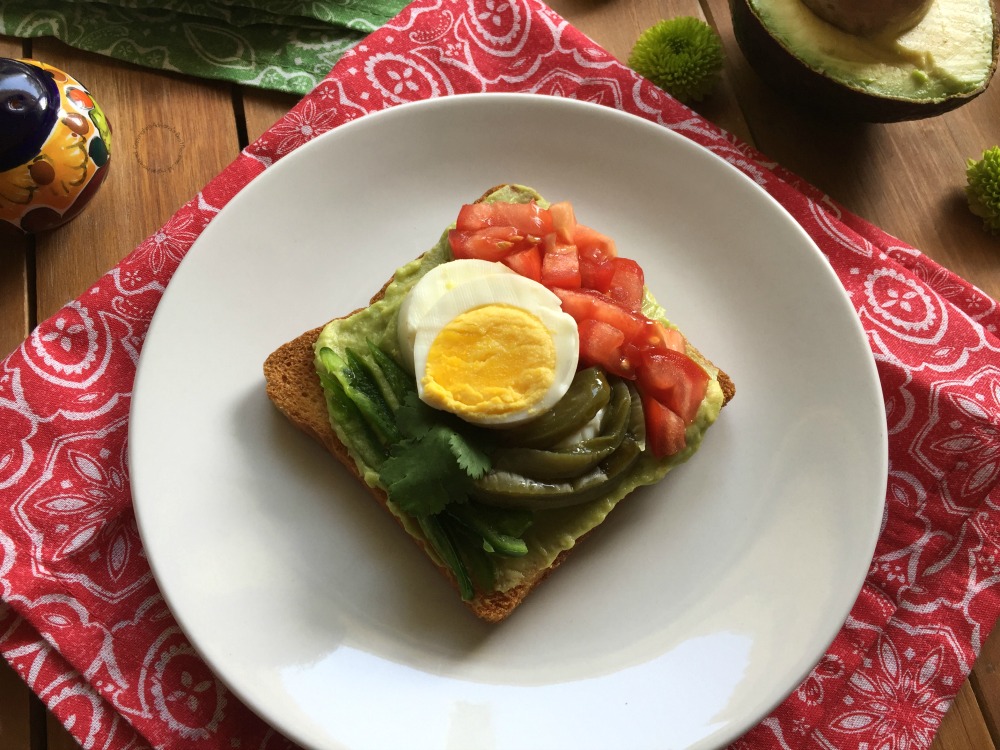 a plate with an opened faced sandwich which has become a food trend