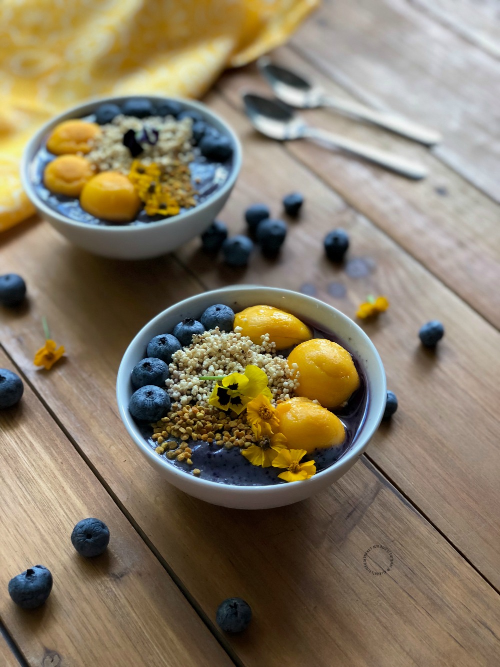 Sensible blueberry power smoothie bowl garnished with edible flowers, amaranth and bee pollen