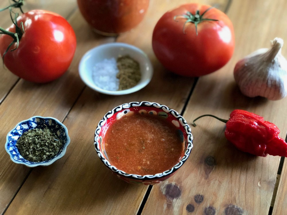 tomatoes, peppers, garlic and condiments in a table