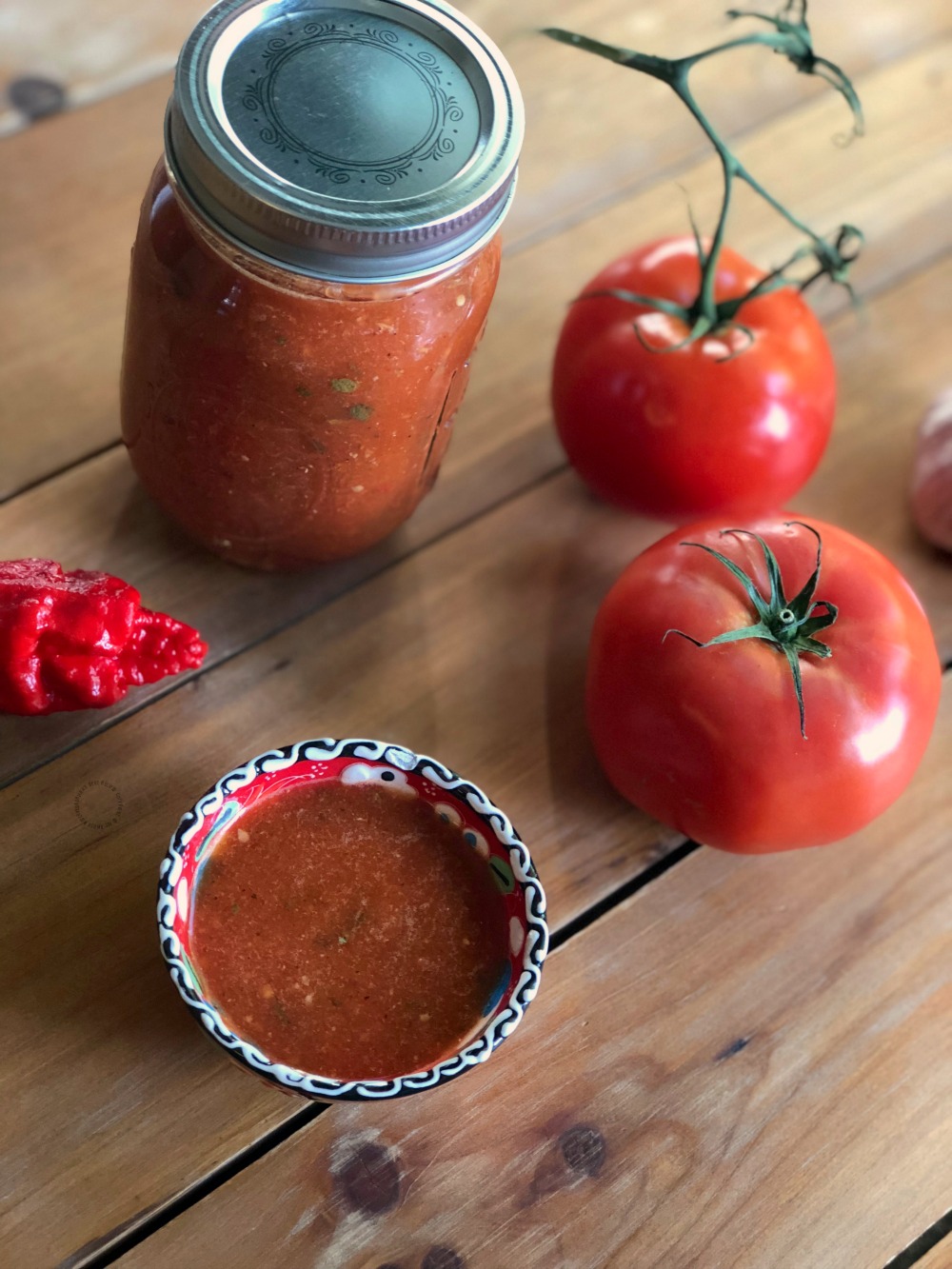 a bowl and a mason jar and tomatoes