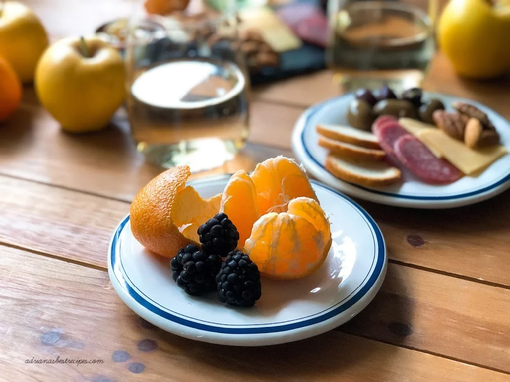 A plate with mandarin and blackberries part of the Italian cheese board for two