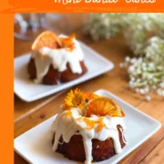 The Cara Cara orange mini bundt cakes have real citrus juice, cream cheese frosting, a fresh glaze made with orange peels and juice, and garnished with beautiful edible flowers and dehydrated orange slices.