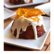 Hornea y comparte estos mini postres con aquellos a quienes amas. Tienen jugo de naranja, betún de queso crema, glaseado de naranja y decoradas con flores comestibles