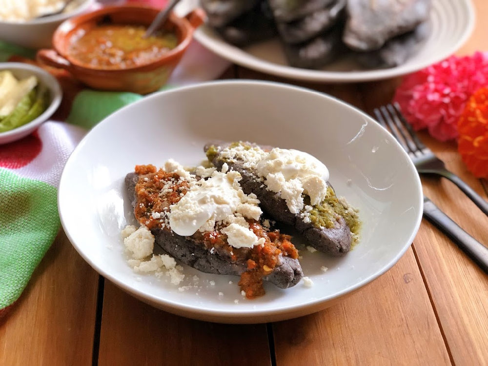 These are the blue corn tlacoyos served with green and red salsa, cream, and crumbled Mexican cheese