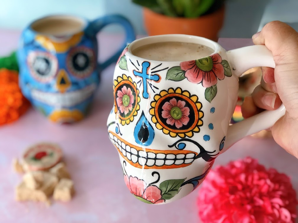 a hand holding a cup with a hot drink