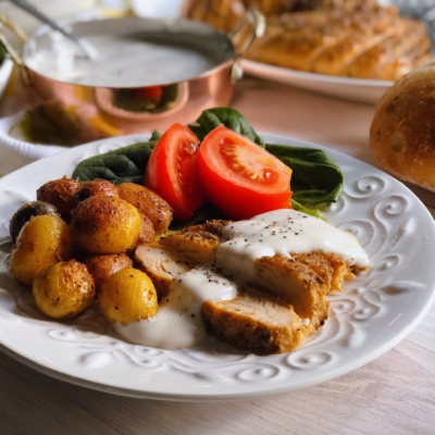 Peppered Turkey Tenderloin with gravy, roasted potatoes, and a spinach tomato salad