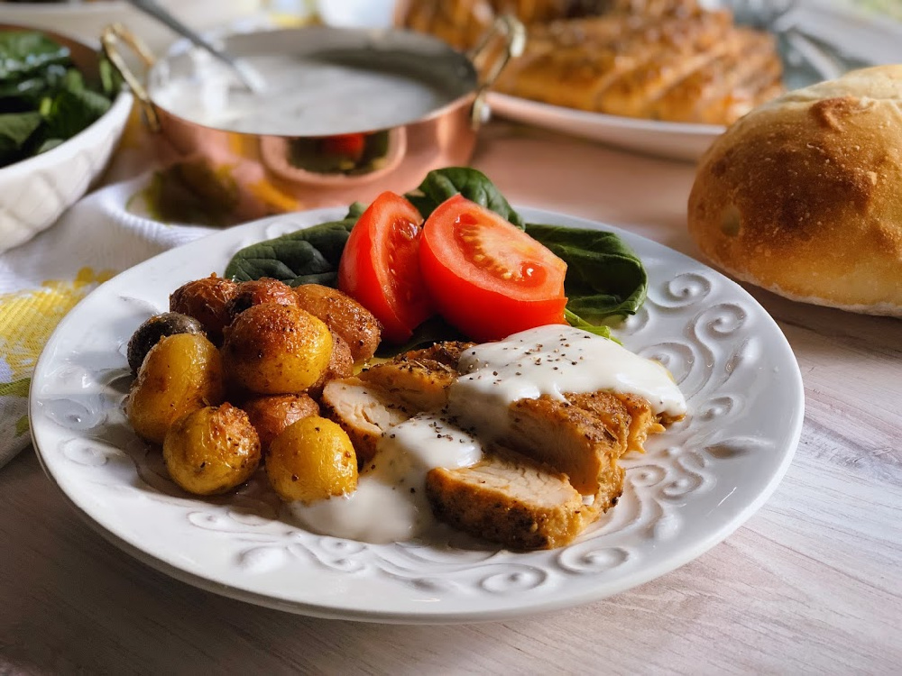 Peppered Turkey Tenderloin with gravy, roasted potatoes, and a spinach tomato salad