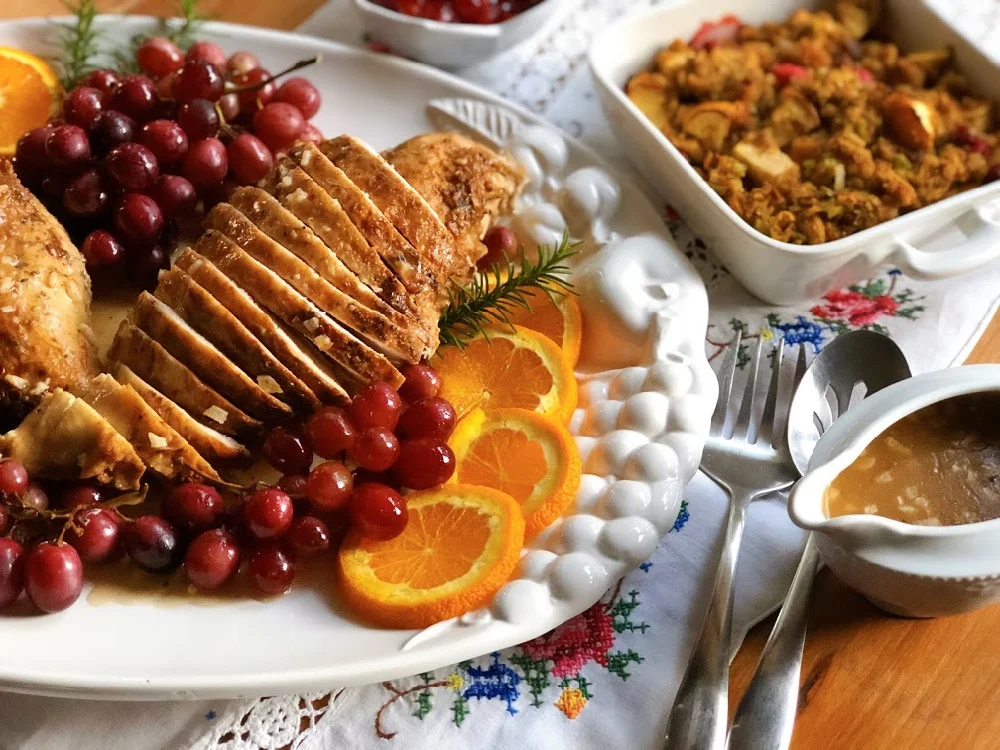 Flavorful roasted garlic turkey dinner with all the fixings, including garlicky gravy, homemade cranberry sauce, bread stuffing, and roasted grapes.