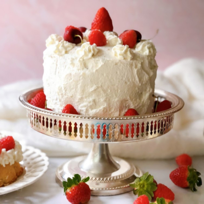 Victoria's Sponge Cake with berries and whipped cream presented on a silver plate