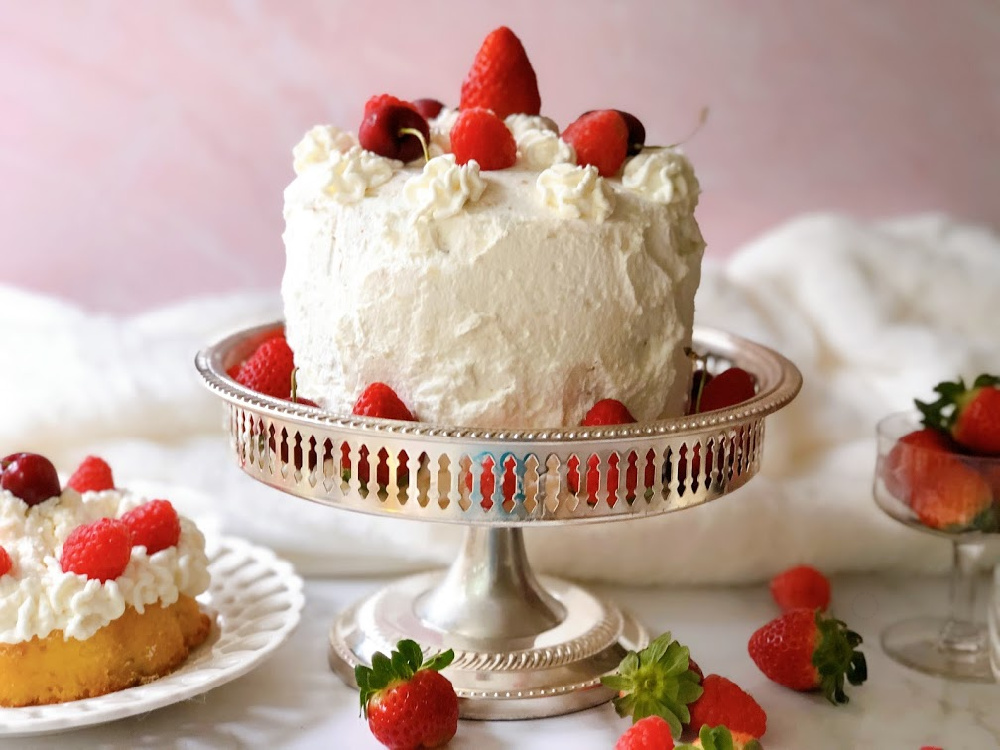 Victoria's Sponge Cake with berries and whipped cream presented on a silver plate