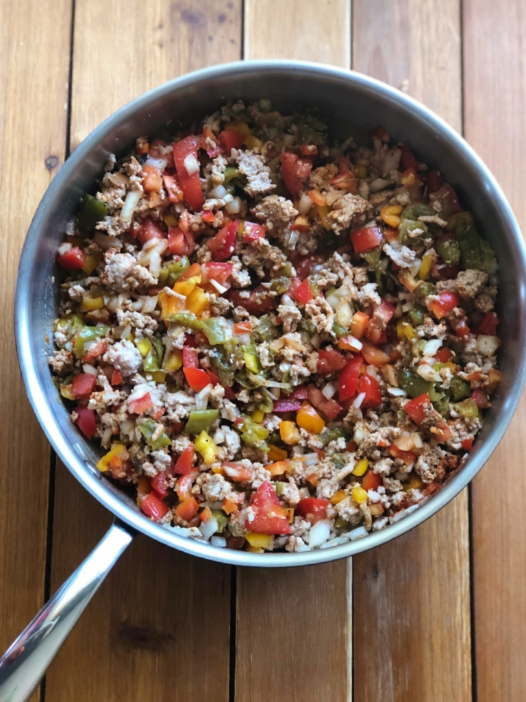 Cooking turkey picadillo in a skillet