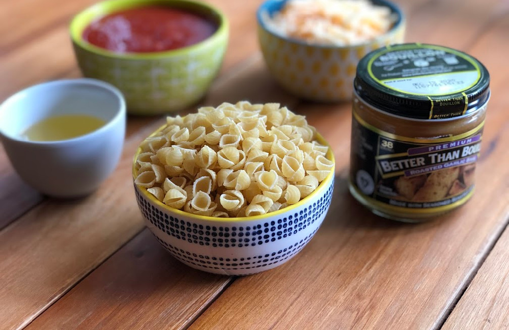 Los ingredientes para la pasta de conchitas con queso incluyen pasta seca, puré de tomate al estilo mexicano, base de ajo Better Than Bouillon, agua, aceite de cocina y queso.