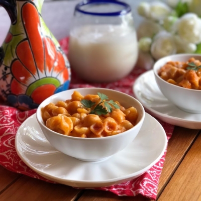 Pasta de Conchitas con Queso hechas con pasta seca en forma de conchita, puré de tomate al estilo mexicano y el condimento Better Than Bouillon sabor ajo todos productos de la canasta básica