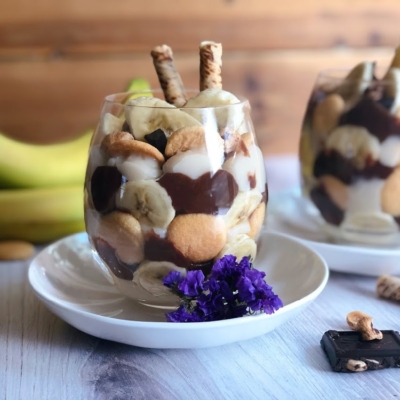 vegan chocolate banana pudding cups with banana slices, hazelnuts, dark chocolate, cookies, and wafers