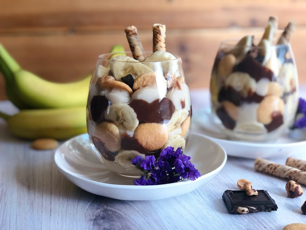 vegan chocolate banana pudding cups with banana slices, hazelnuts, dark chocolate, cookies, and wafers