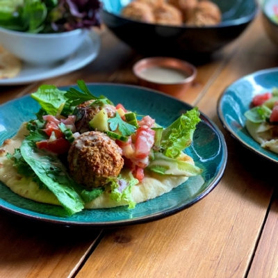 a plate with plant-based meatballs over a bed of greens