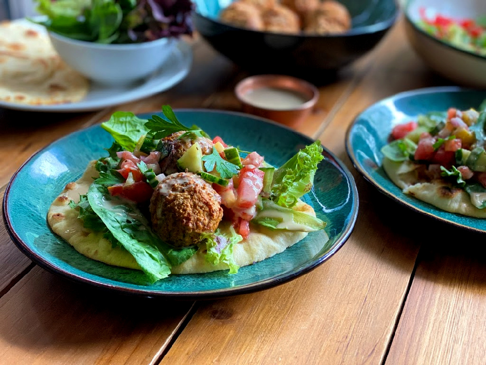 un plato con albóndigas de origen vegetal sobre una cama de verduras