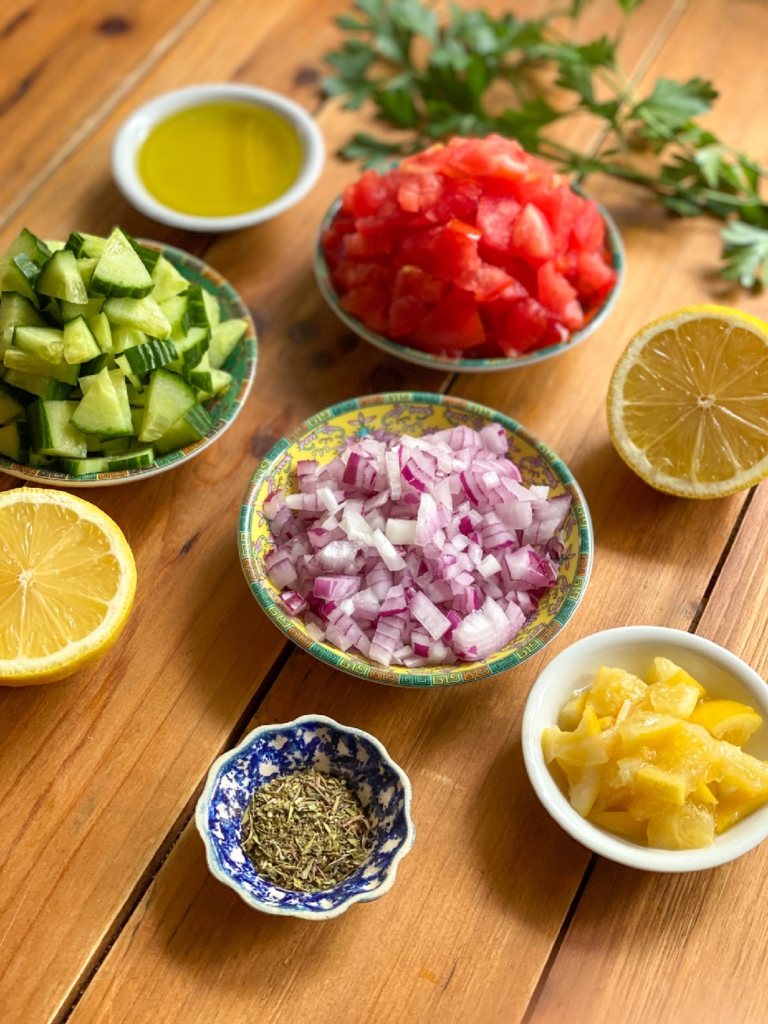 Los ingredientes para la salsa de pepino incluyen limones en conserva, tomate, cebolla morada, jugo de limón, aceite de oliva y especias italianas.