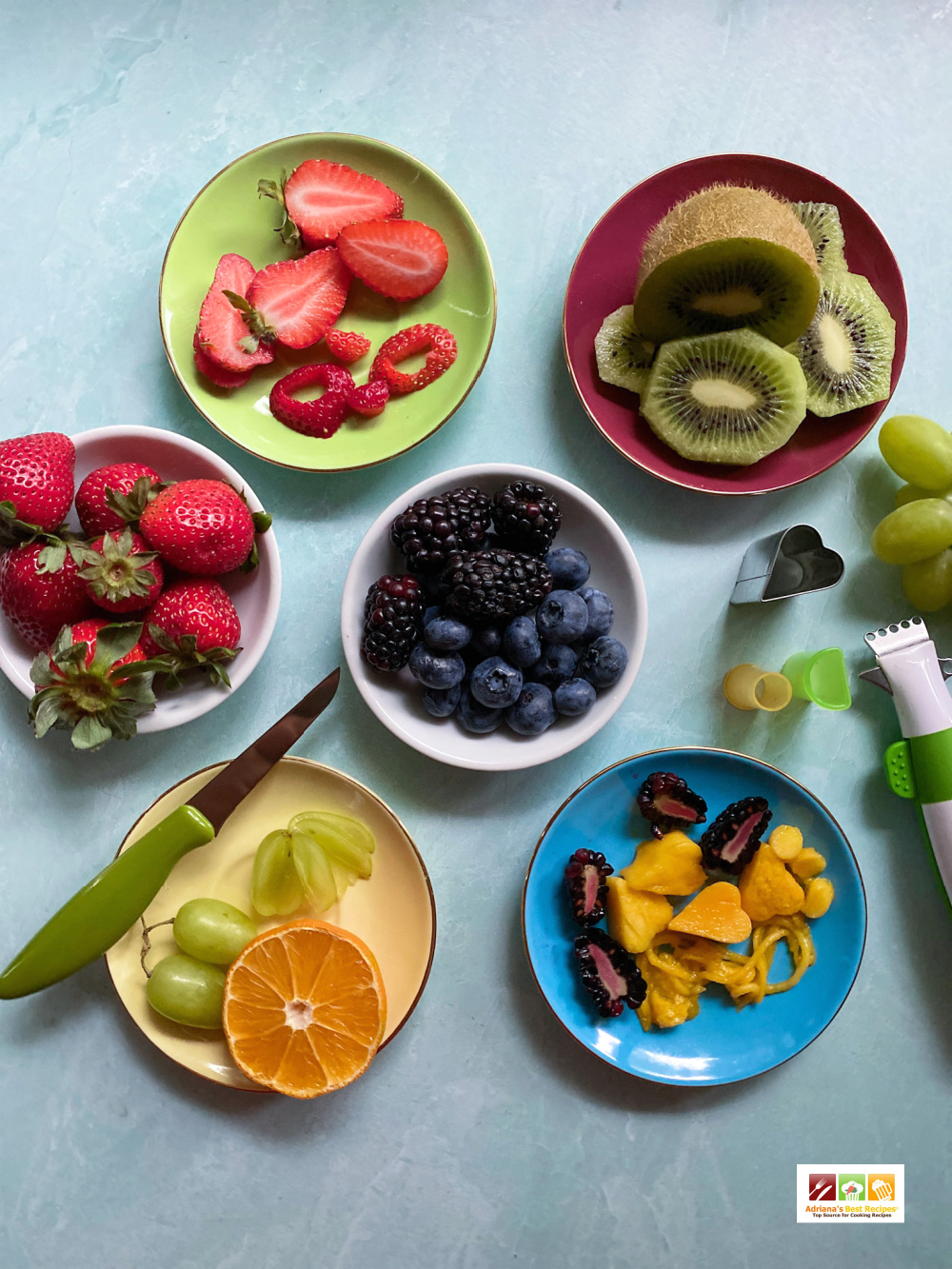 six round plates with fruit cutouts and fruit cutters 