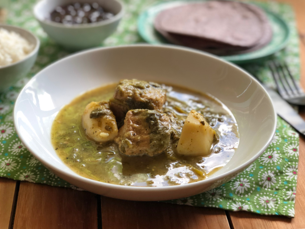 A white bowl of Purslane Pork in Tomatillo Sauce cooked on the Instant Pot
