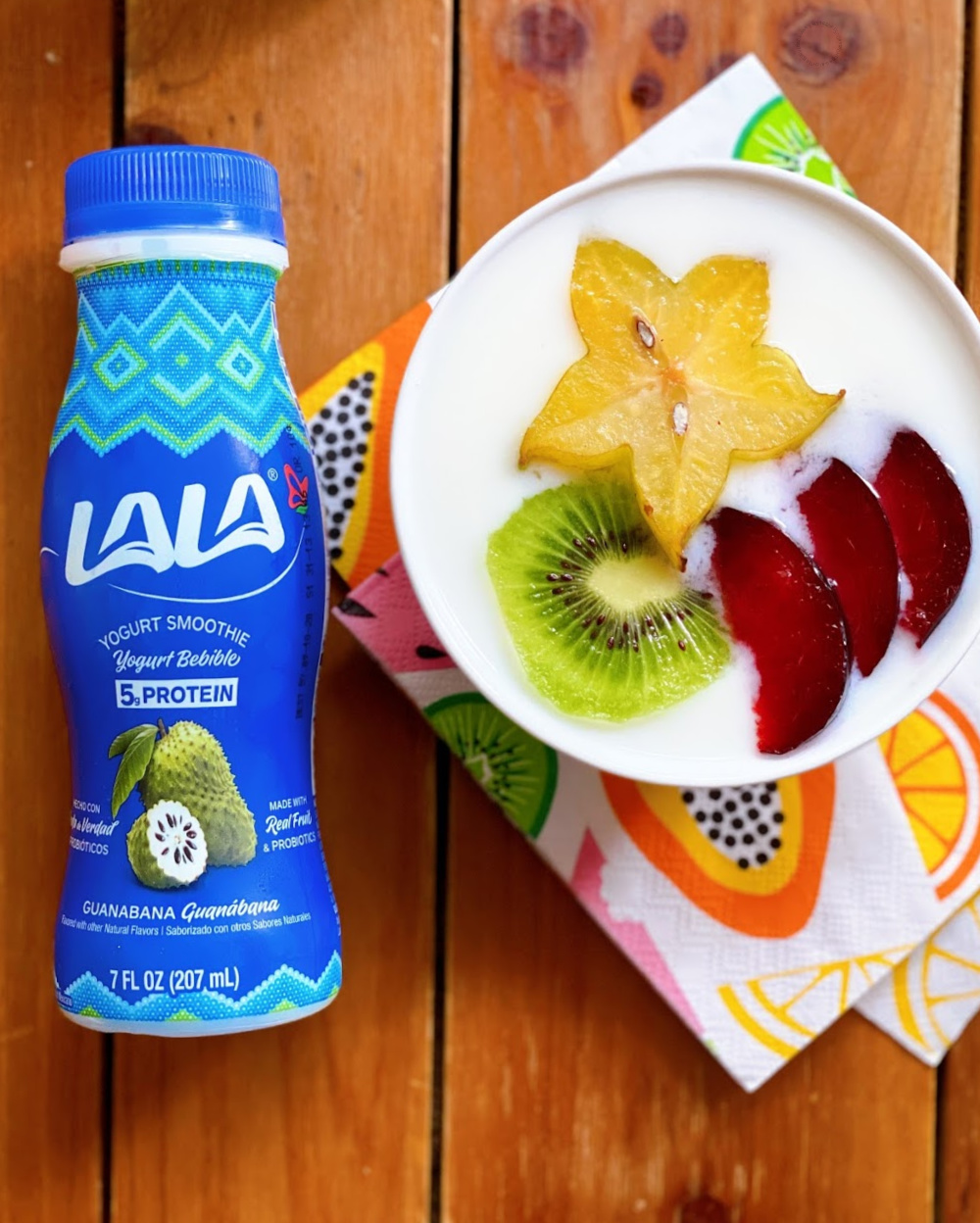 A colorful smoothie bowl with kiwi, star fruit, and plum slices