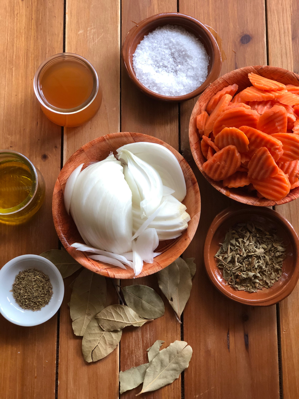 Una foto superior que muestra dos tazones con cebollas y zanahorias y otras especias