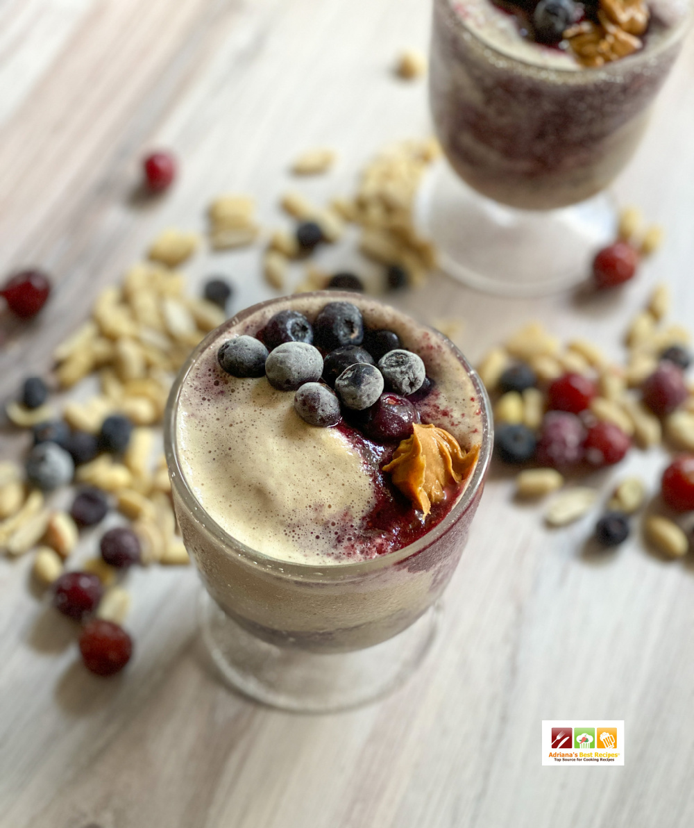 a smoothie topped with frozen blueberries and peanut butter