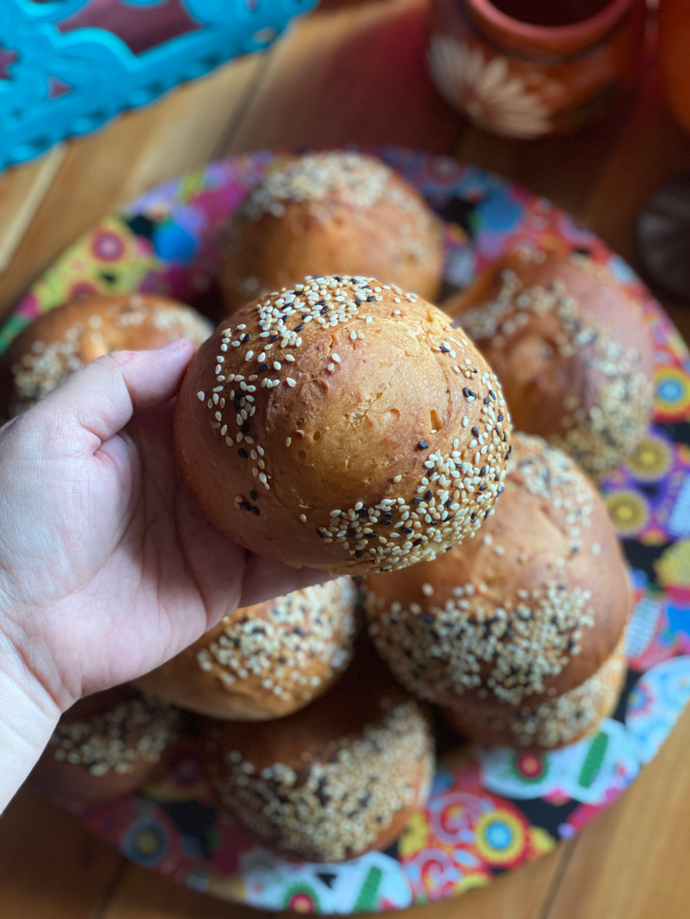 una mano sosteniendo un bollo de pan artesanal