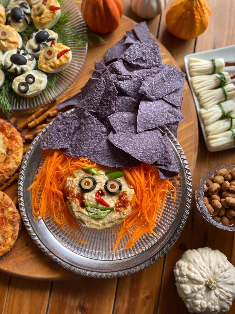 A tablescape with witch themed food and Halloween party bites