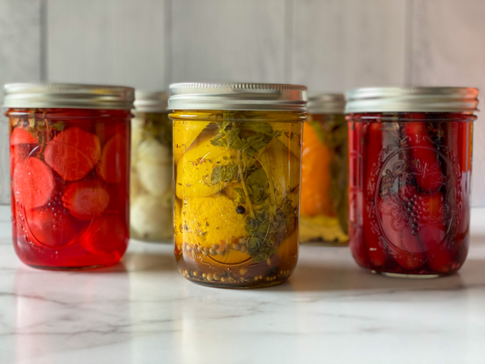 Mason jars with radishes, lemons and carrots