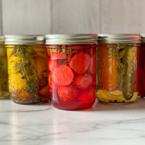 A group of jars with pickled veggies