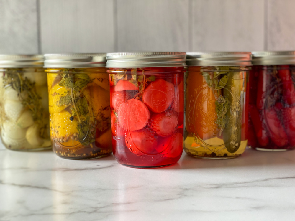 A group of jars with pickled veggies