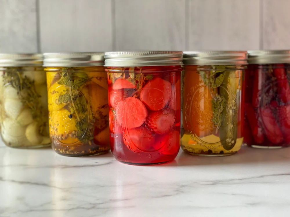 A group of jars with pickled veggies