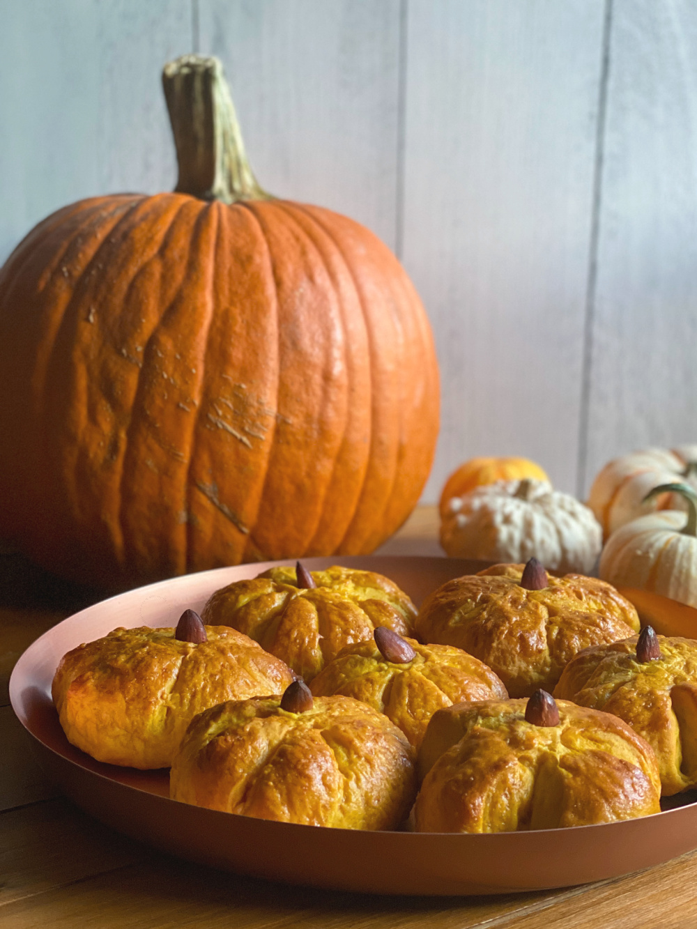 Pumpkin shaped dinner rolls served on a tray