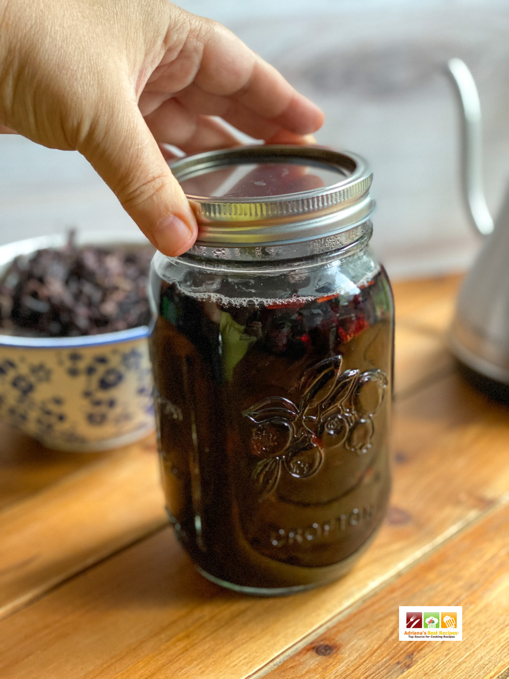 a hand closing a mason jar