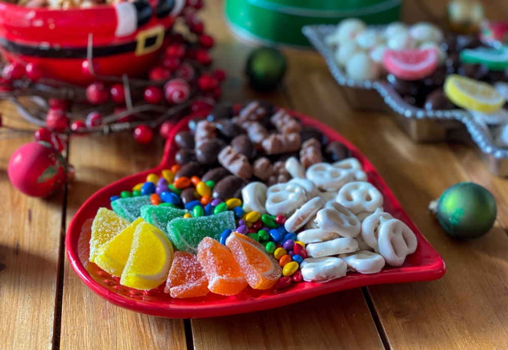 A heart-shaped plate with gummies and pretzels yummy Christmas movie snacks and candy options