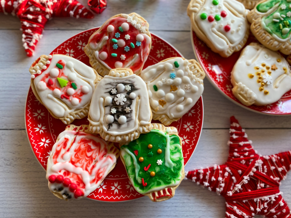 Un plato con galletas con diseños de de suéteres feos