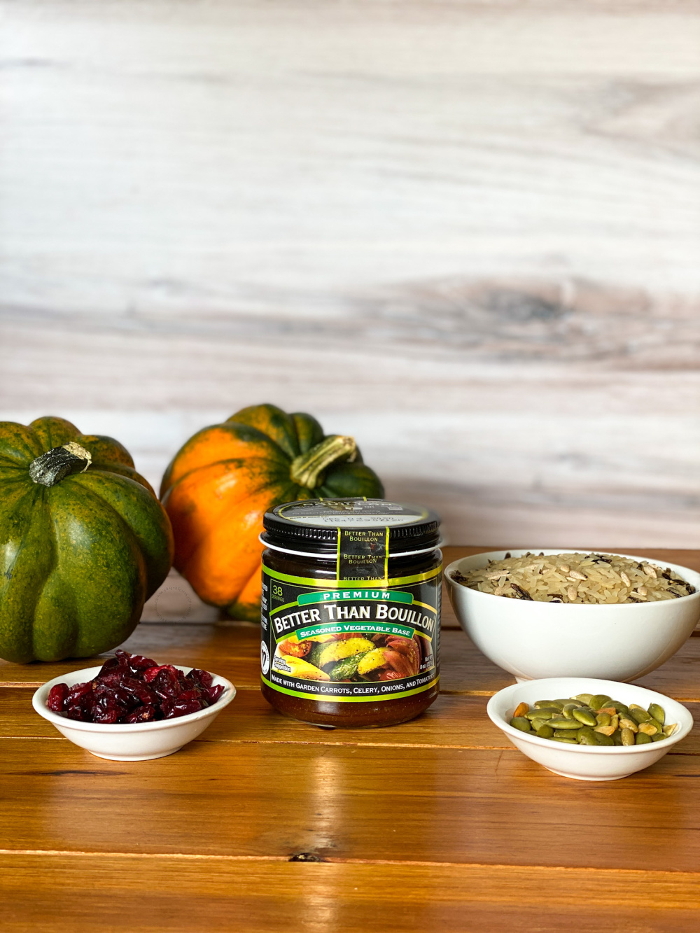 a container of vegetable bouillon, a bowl of wild rice, dried cranberries and pepitas