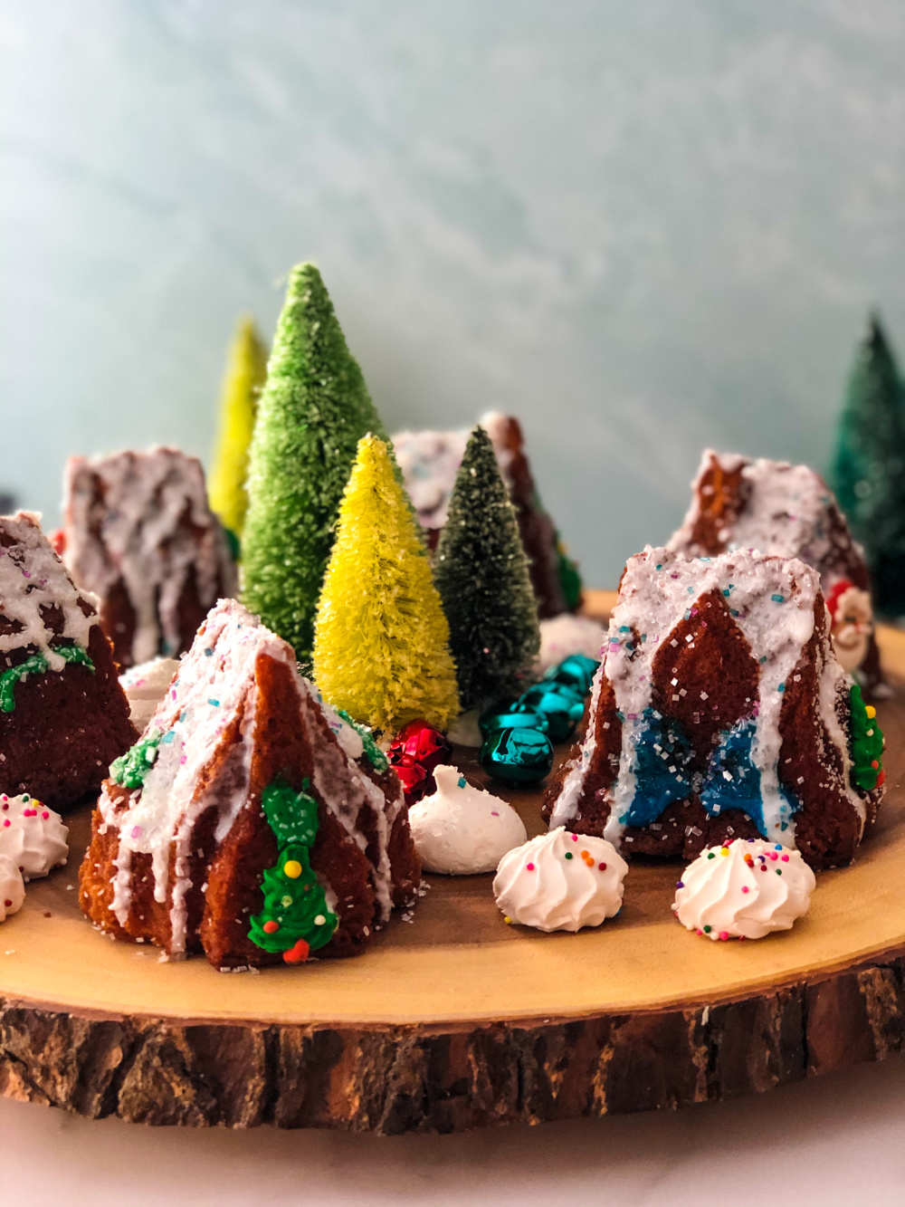 La configuración del pueblo navideño comestible requiere de una superficie de madera, merengues y cascabeles de colores.