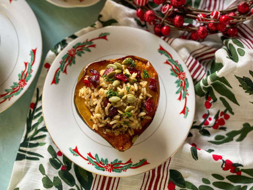 vegetarian stuffed acorn squash with wild rice served on a holiday plate