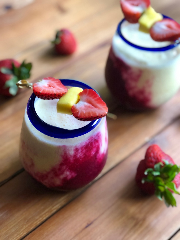 two glasses with fruit skewers added as a garnish