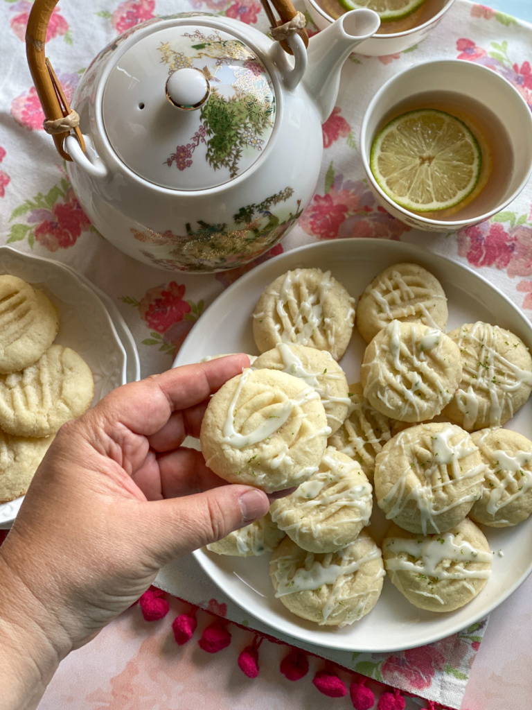 A hand holding a lime glazed butter biscuit