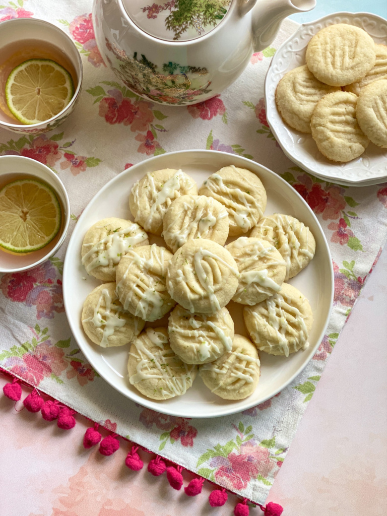 Una mesa preparada para la hora del té con galletas y té de limón.